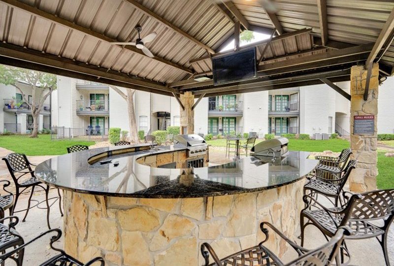 outdoor kitchen with grill and seating area at The Westmount at River Park