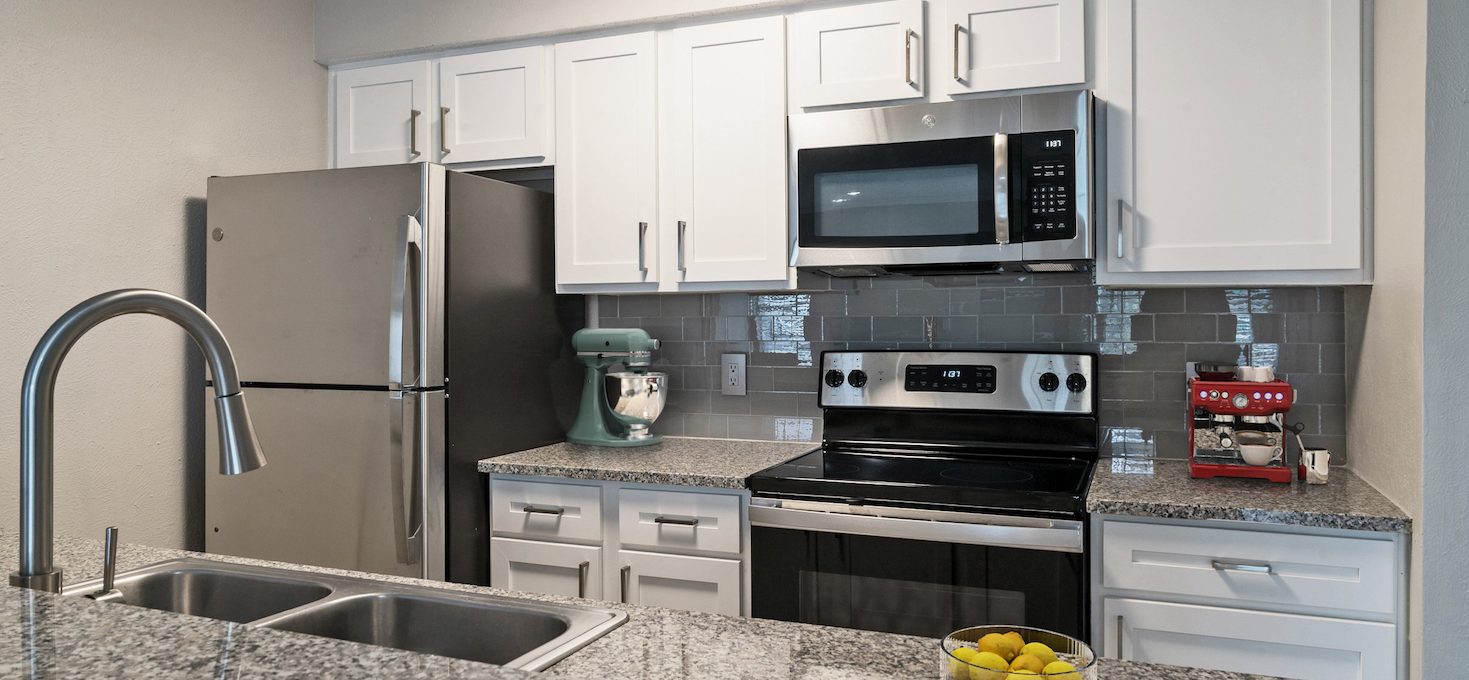 a kitchen with granite counter tops and stainless steel appliances at The Westmount at River Park