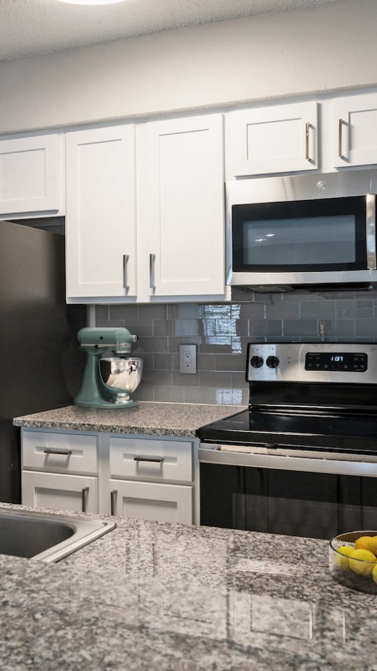 a kitchen with granite counter tops and stainless steel appliances at The Westmount at River Park